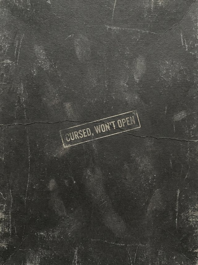 An unmarked black box, stamped: cursed, won't open